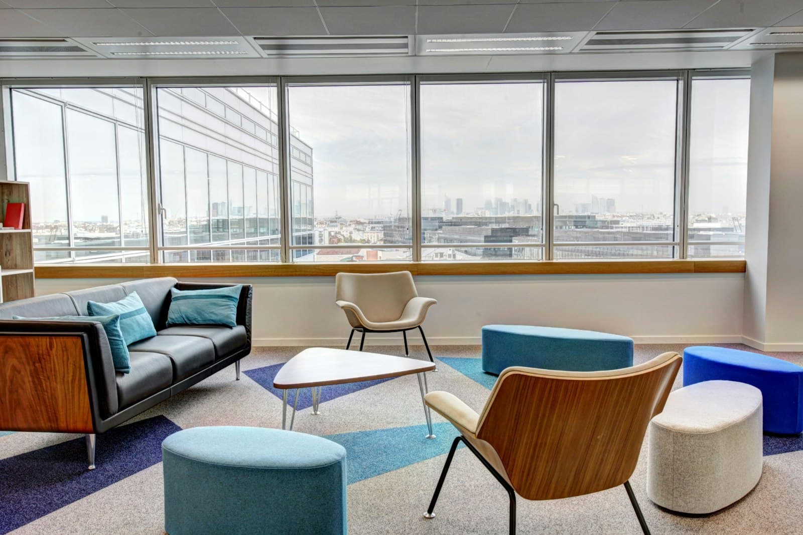 Lichte, propere moderne kantoorlounge met grote ramen